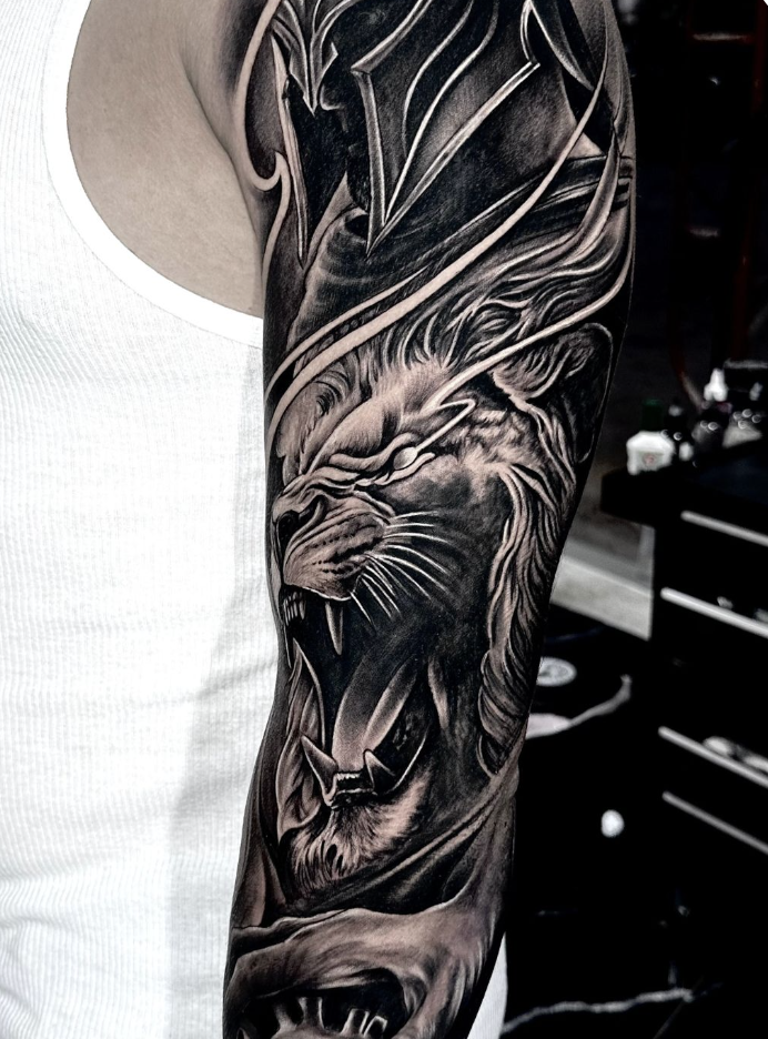 Black and gray realism forearm tattoo of a roaring lion