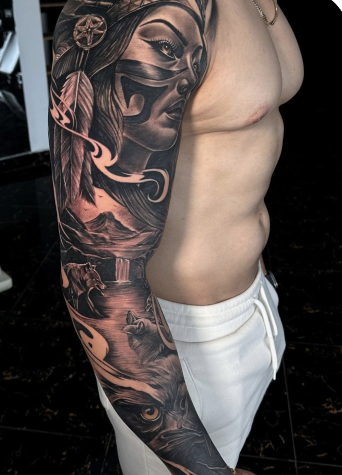 Black and gray full sleeve tattoo composition with portrait and wildlife elements